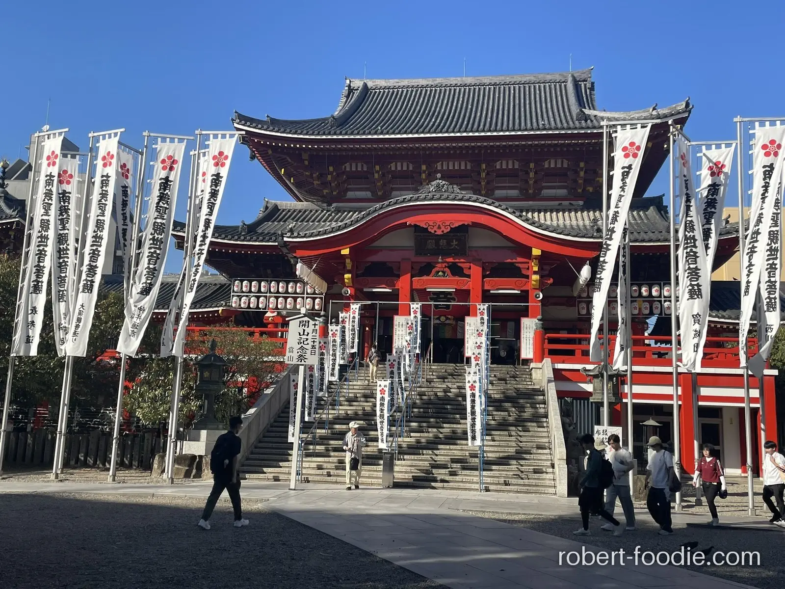 大須觀音寺朱紅色本堂，石階兩側立著白色幟旗